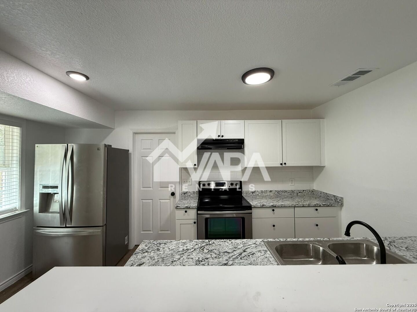 7422 Pipe Spring Street San Antonio, TX 78238 - Photo 7 of 13 a kitchen with granite countertop a refrigerator and a stove top oven