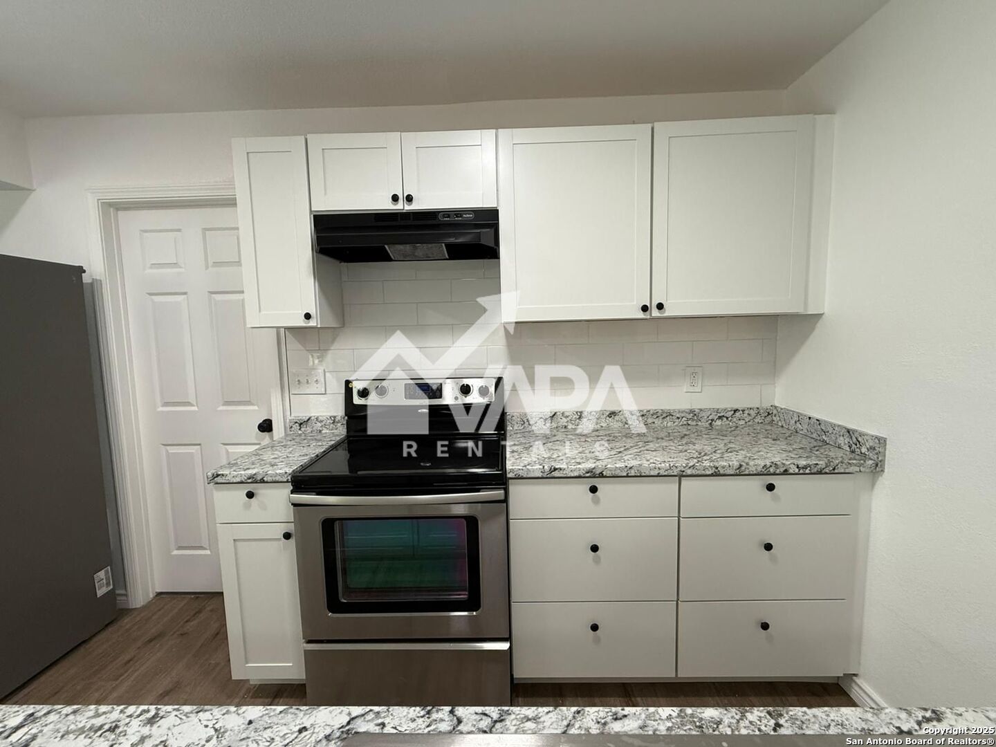 7422 Pipe Spring Street San Antonio, TX 78238 - Photo 10 of 13 a kitchen with granite countertop a stove and a white cabinets