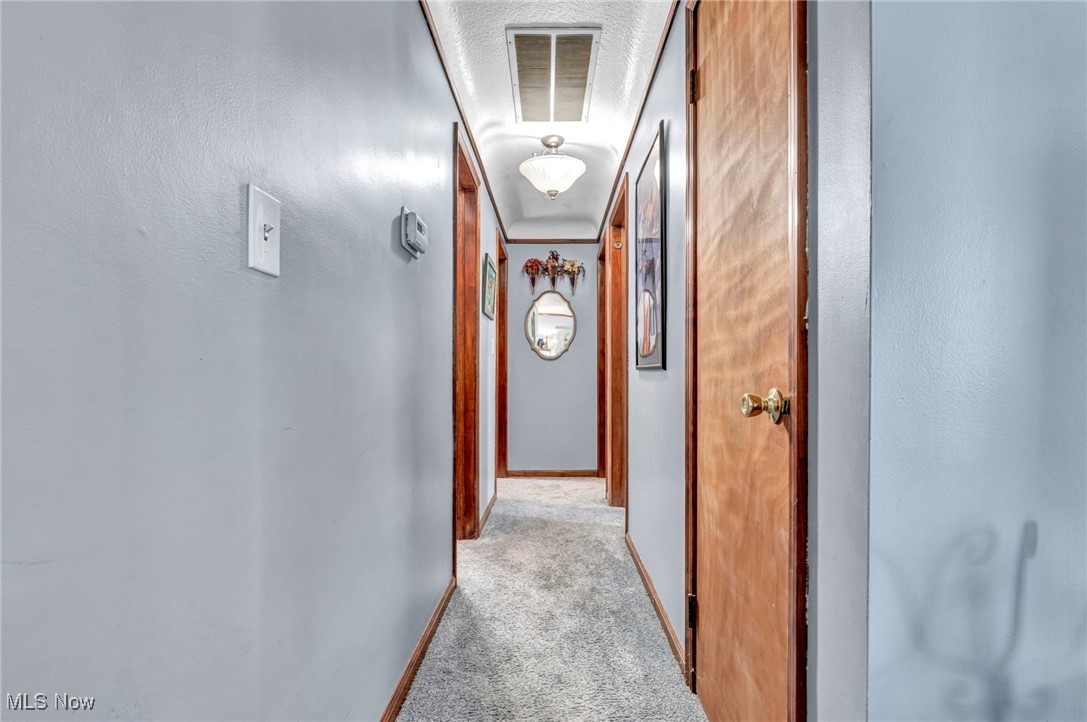 8164 Edgewood Road Mentor, OH 44060 - Photo 29 of 42 Corridor with ornamental molding and light colored carpet