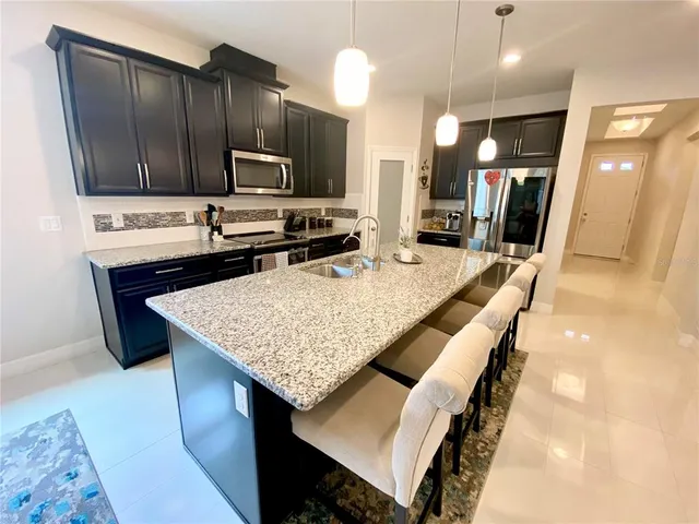 a kitchen with a table chairs refrigerator and microwave