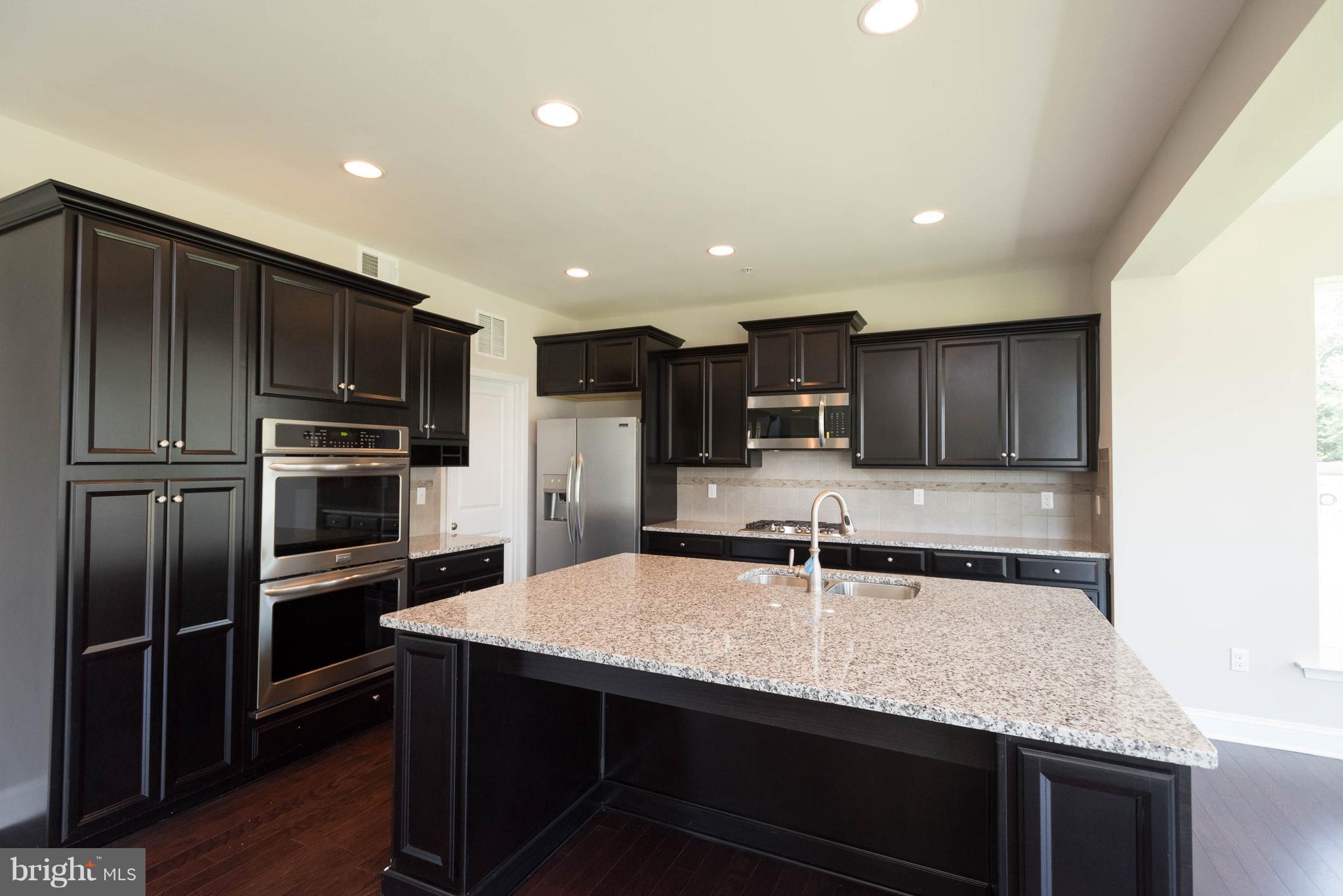 9763 Powder Hall Road Perry Hall, MD 21128 - Photo 11 of 30 a kitchen with kitchen island granite countertop a sink and stainless steel appliances