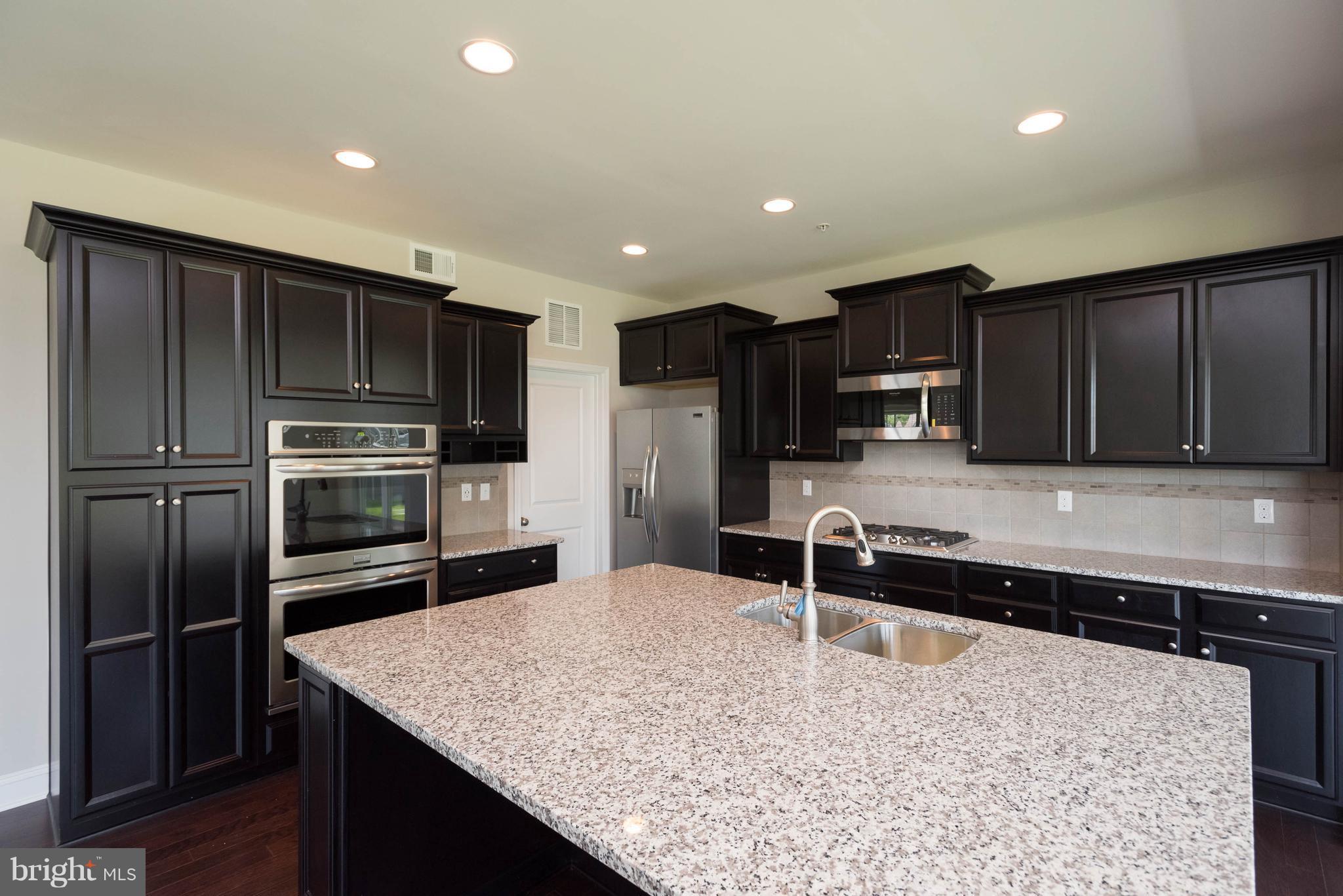 9763 Powder Hall Road Perry Hall, MD 21128 - Photo 13 of 30 a kitchen with stainless steel appliances kitchen island granite countertop a refrigerator and a sink