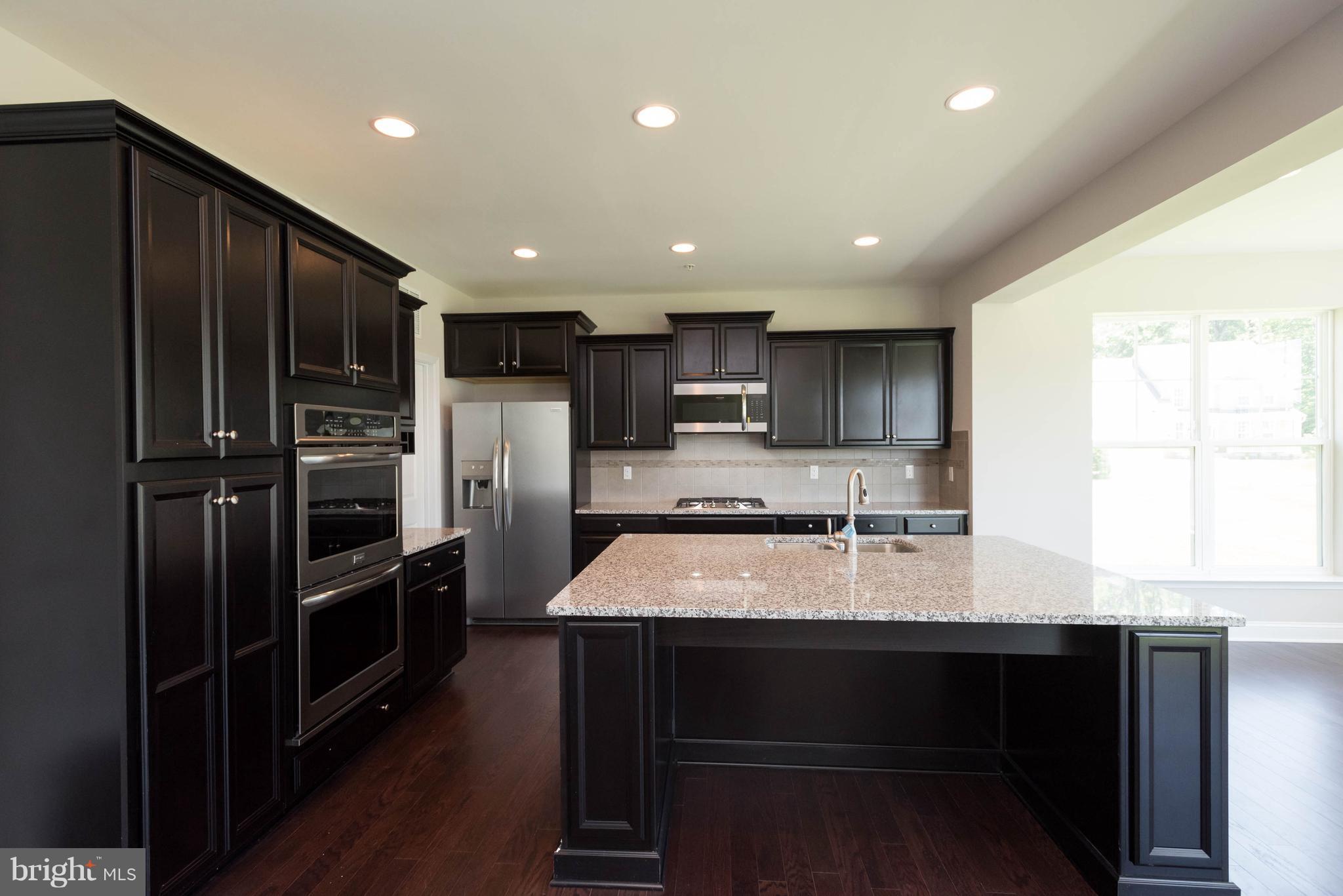 9763 Powder Hall Road Perry Hall, MD 21128 - Photo 14 of 30 a kitchen with refrigerator cabinets and wooden floor