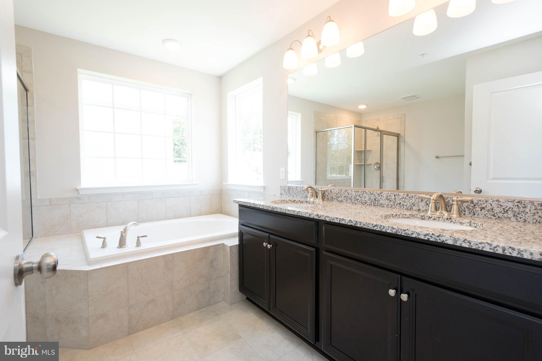 9763 Powder Hall Road Perry Hall, MD 21128 - Photo 20 of 30 a bathroom with a granite countertop bathtub a double vanity sink and mirror