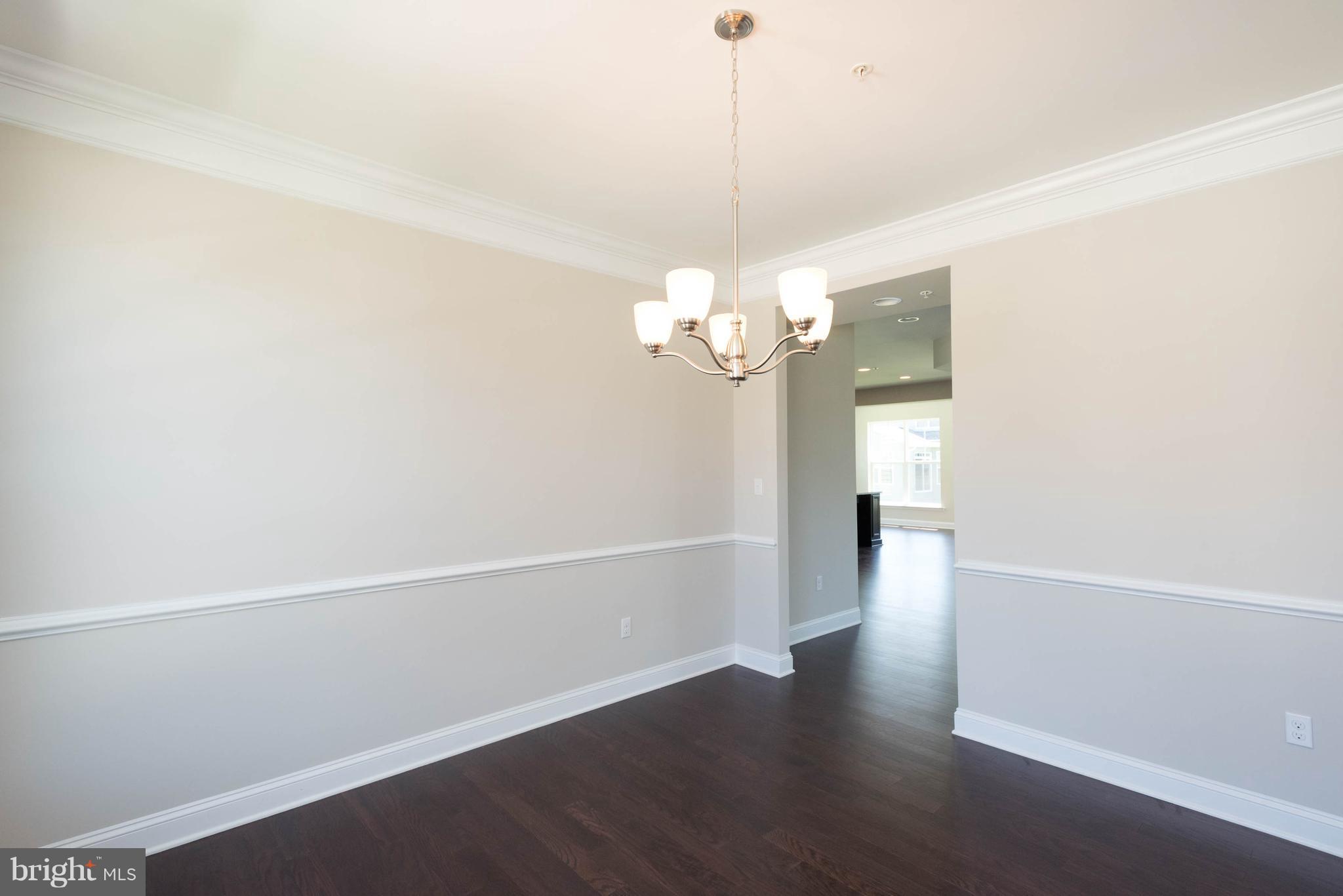 9763 Powder Hall Road Perry Hall, MD 21128 - Photo 7 of 30 a view of a hallway with wooden floor and a chandelier