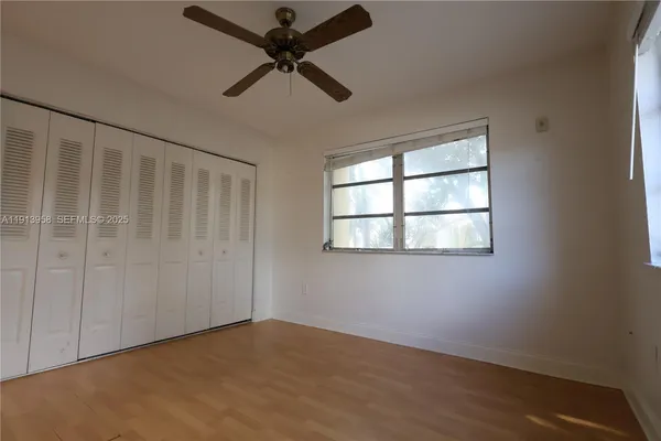 an empty room with a window and a fan