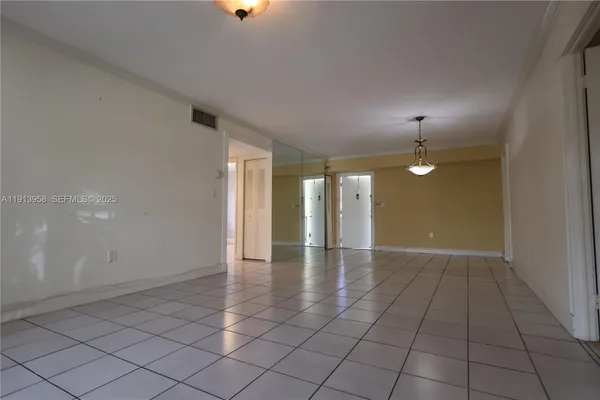 an empty room with glass door and chandelier fan