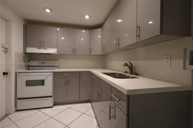 a kitchen with a sink a stove and cabinets
