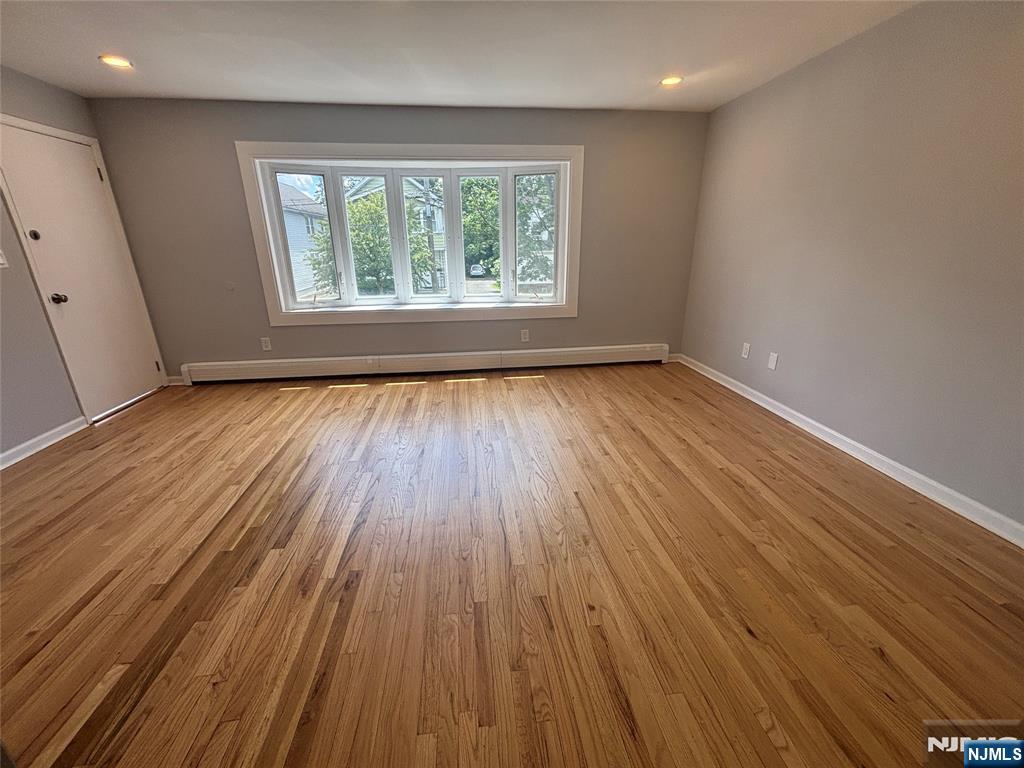 34 Warman Street, Unit 2 Montclair, NJ 07042 - Photo 3 of 11 an empty room with wooden floor and windows