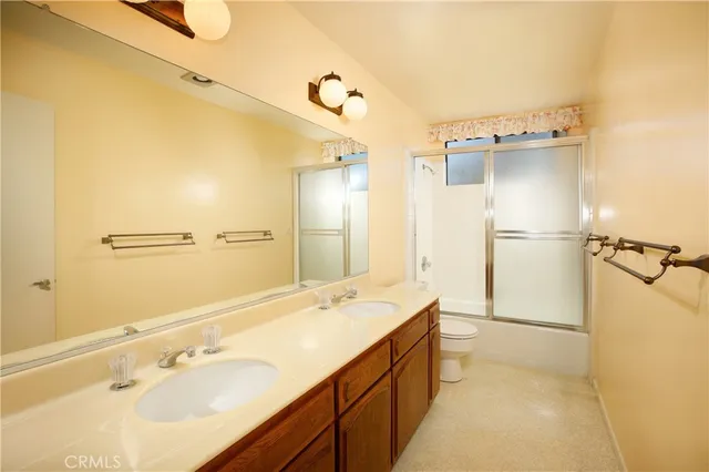 a bathroom with a double vanity sink a mirror and a bathtub
