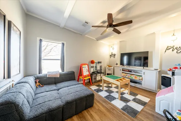 a living room with furniture kitchen view and a window