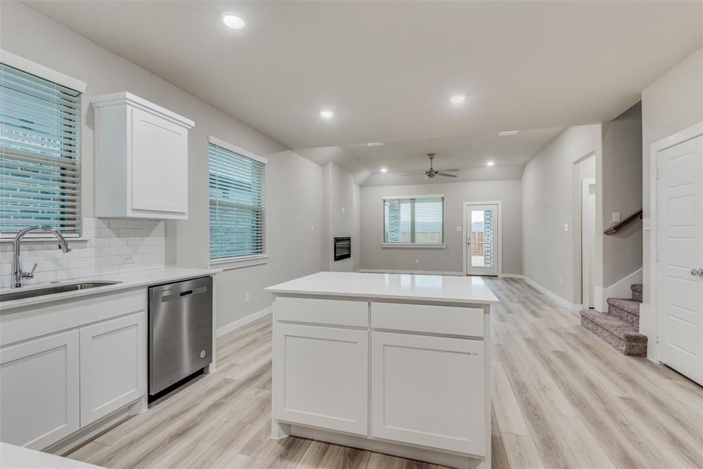 2544 Rambling Road Celina, TX 75009 - Photo 10 of 25 Kitchen featuring light wood-type flooring, stainless steel dishwasher, white cabinets, backsplash, and sink