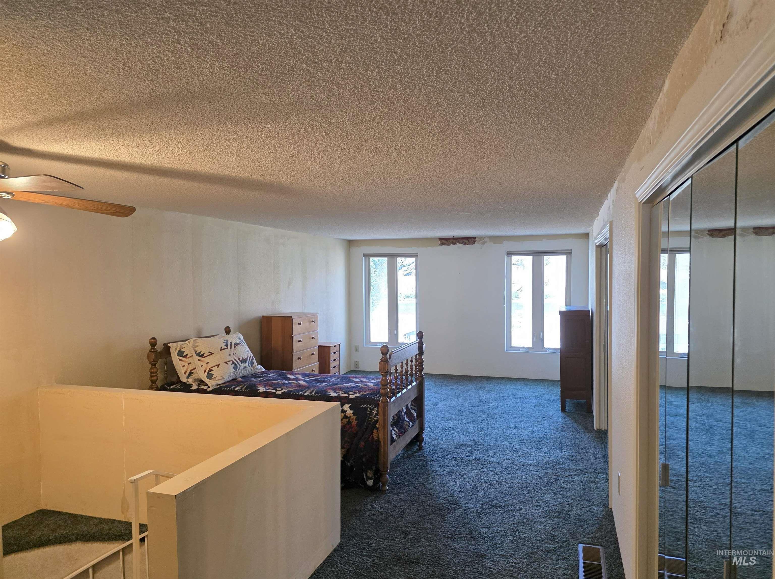 209 Harding Street Asotin, WA 99402 - Photo 16 of 29 Bedroom with dark carpet, a textured ceiling, and a ceiling fan