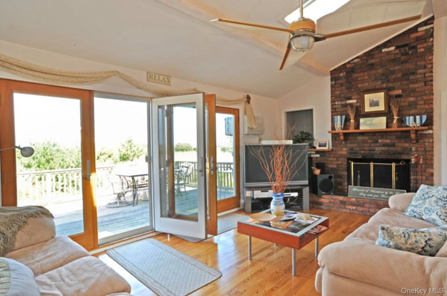900 Dune Road Westhampton Beach, NY 11978 - Photo 12 of 14 a living room with furniture a fireplace next to a large window
