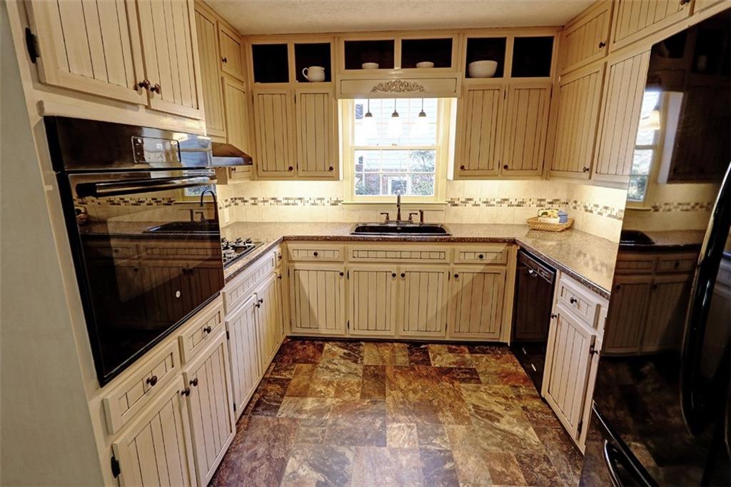 253 Newport Road Southwest Lilburn, GA 30047 - Photo 11 of 40 a kitchen with granite countertop a sink stove and cabinets