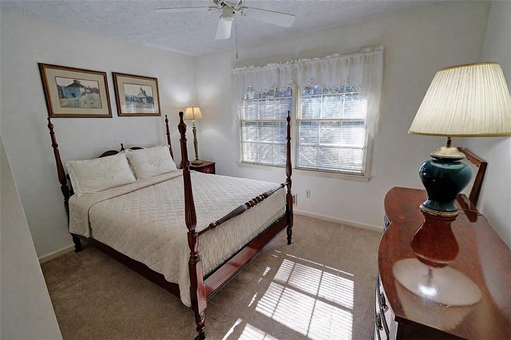 253 Newport Road Southwest Lilburn, GA 30047 - Photo 18 of 40 a bed room with a bed and a lamp