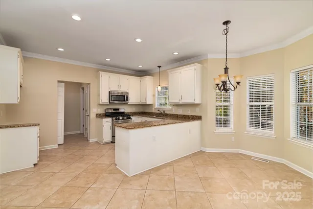a kitchen with stainless steel appliances granite countertop a stove top oven a sink a counter top space and cabinets