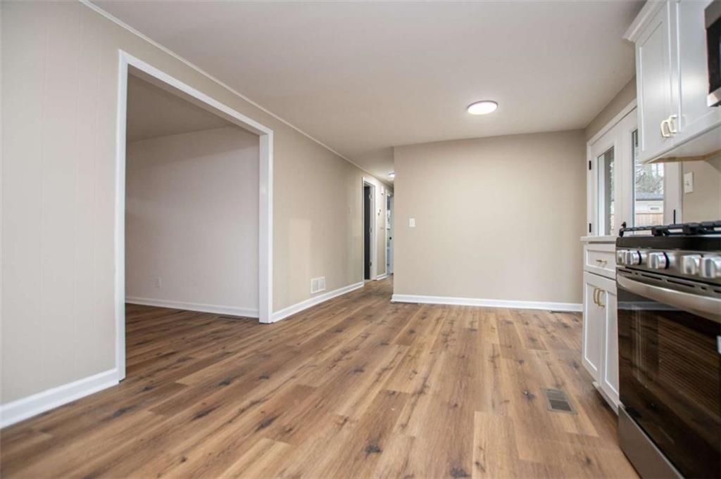 757 North Burnt Hickory Road Douglasville, GA 30134 - Photo 18 of 51 a view of kitchen stove hallway with wooden floor and fireplace