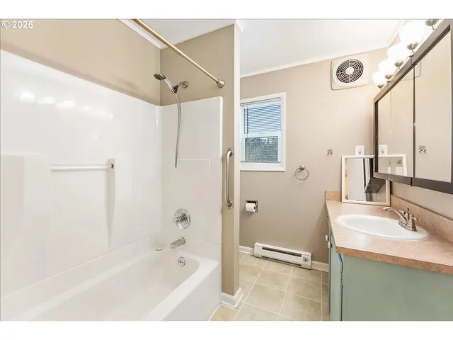 a bathroom with a tub sink and mirror