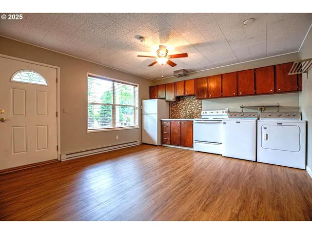 a kitchen with kitchen island wooden floors and stainless steel appliances