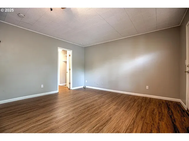 a view of an empty room with wooden floor