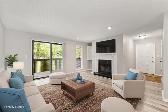 a living room with furniture a fireplace and a floor to ceiling window