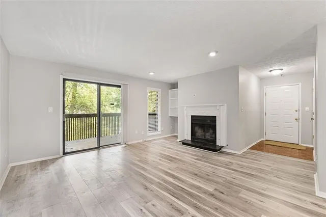 a view of an empty room with a fireplace and a window