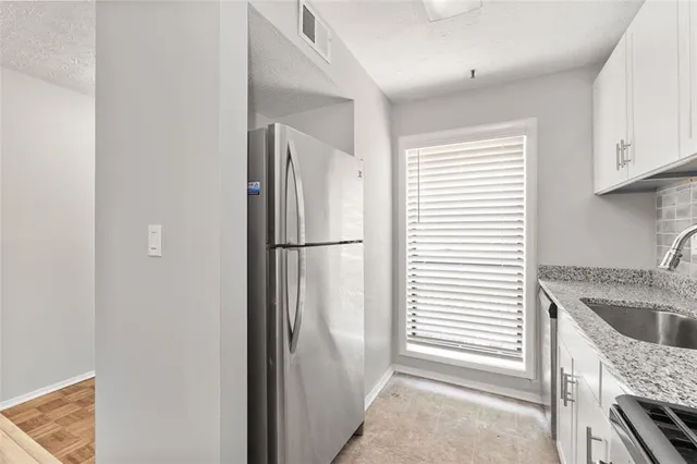 a kitchen with stainless steel appliances granite countertop a refrigerator and a sink