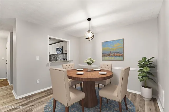 a dining room with furniture potted plants and wooden floor