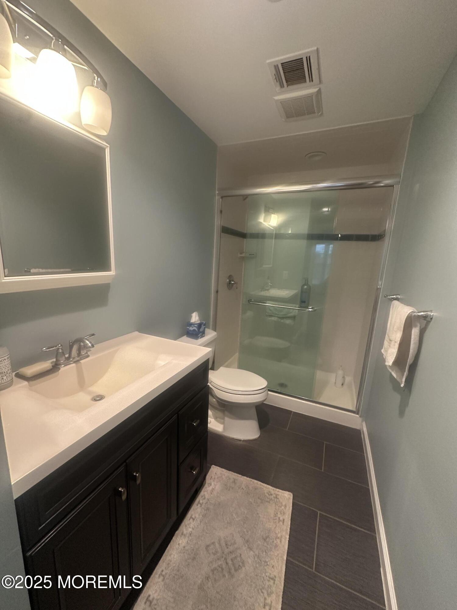 177 Main Street, Unit 2B Manasquan, NJ 08736 - Photo 11 of 13 a bathroom with a sink a toilet a mirror and shower