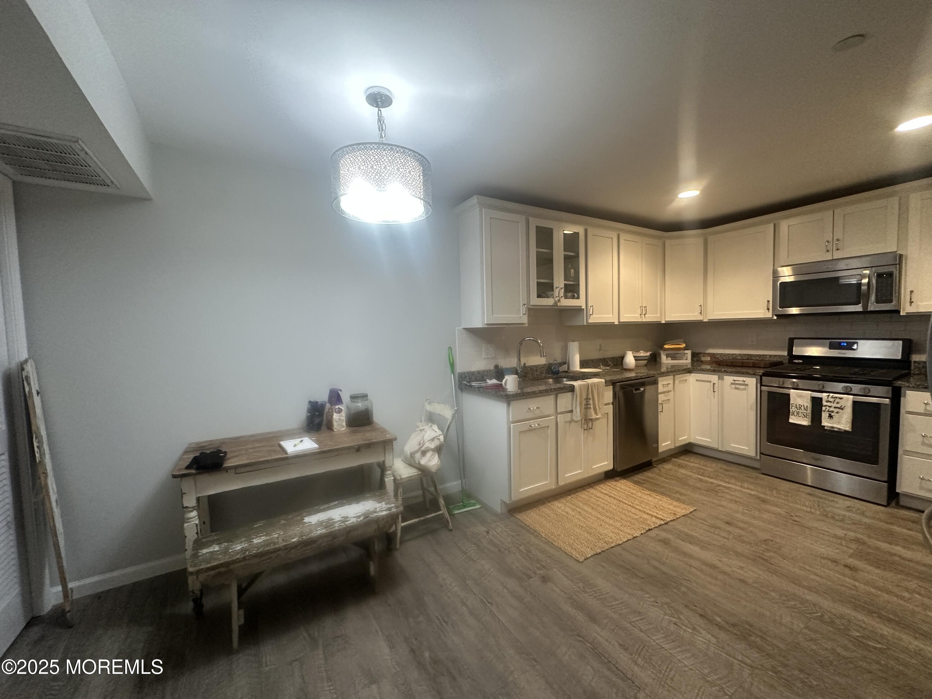 177 Main Street, Unit 2B Manasquan, NJ 08736 - Photo 3 of 13 a kitchen with kitchen island granite countertop stainless steel appliances cabinets a sink and a wooden floor
