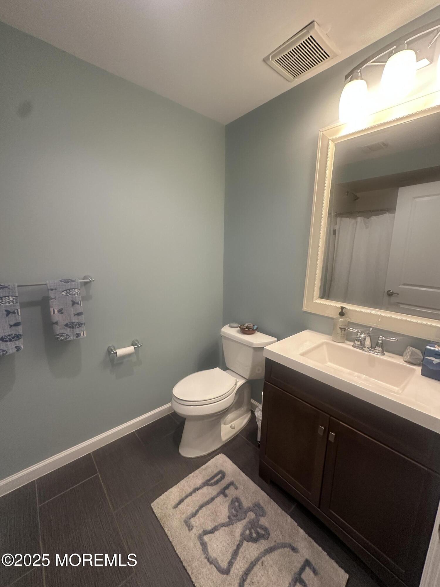 177 Main Street, Unit 2B Manasquan, NJ 08736 - Photo 6 of 13 a bathroom with a toilet sink and mirror