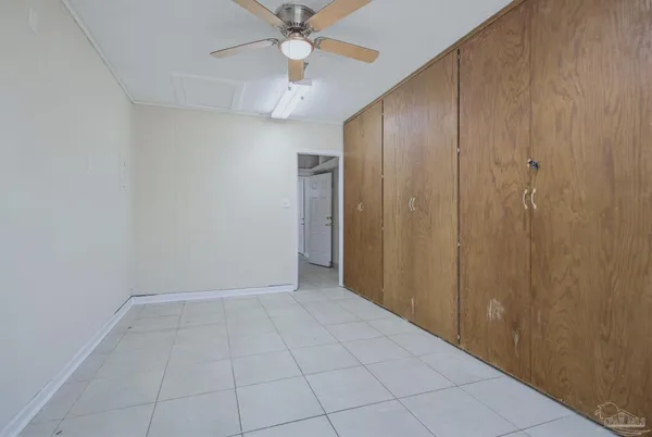 an empty room with closet and a chandelier fan