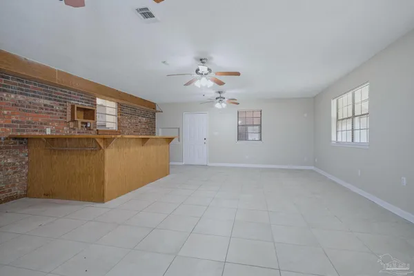 a view of a livingroom with a chandelier fan and windows