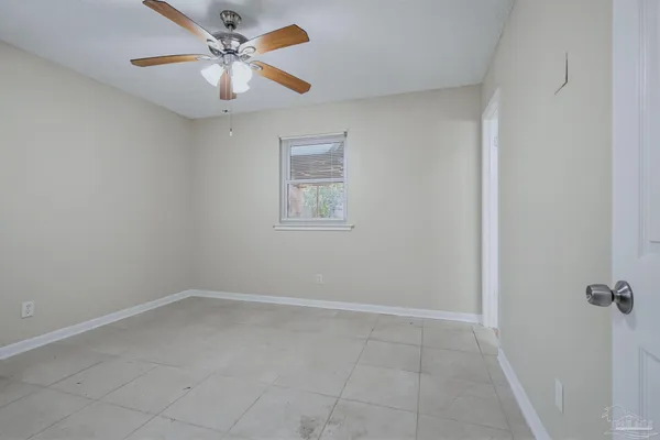 an empty room with a window and a fan