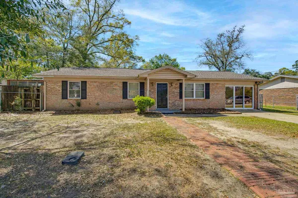 a front view of house with yard and trees around