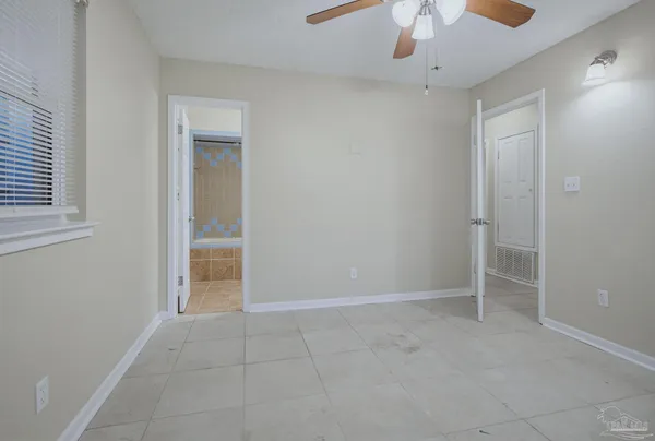 an empty room with closet and a chandelier fan