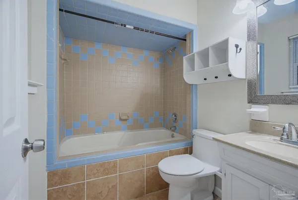 a bathroom with a granite countertop toilet a sink and a bathtub