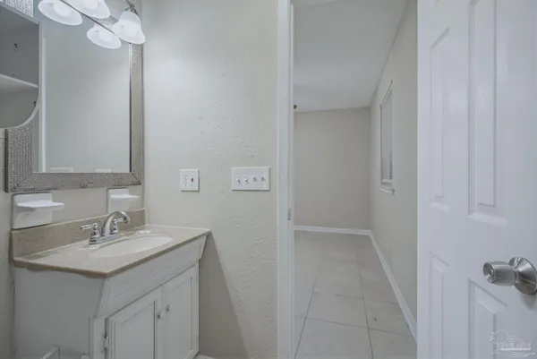 a bathroom with a sink a light fixture and a mirror