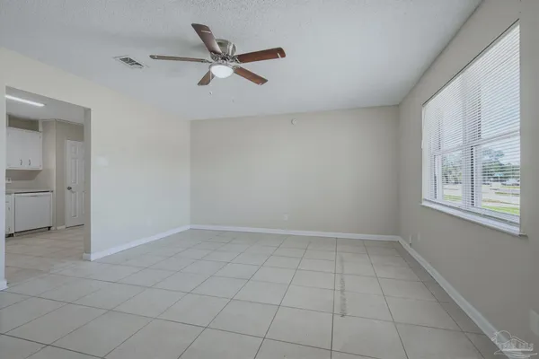an empty room with windows and ceiling fan