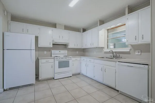 a kitchen with cabinets appliances a sink and a window