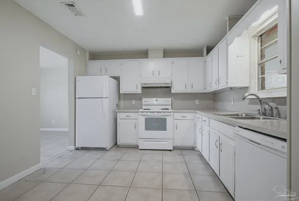 a kitchen with cabinets appliances a sink and a counter top space