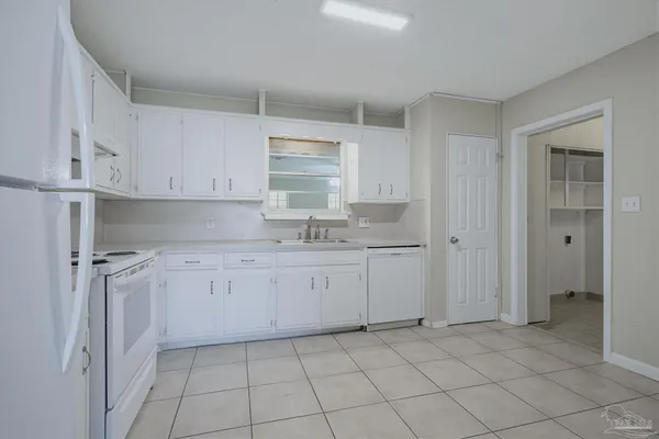 a kitchen with granite countertop white cabinets and stainless steel appliances