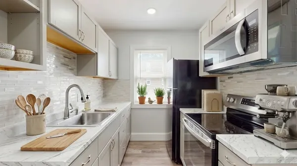 a kitchen with stainless steel appliances granite countertop a sink and a stove