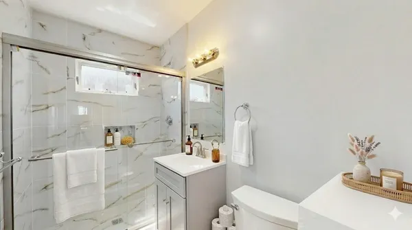 a bathroom with a sink a toilet and shower