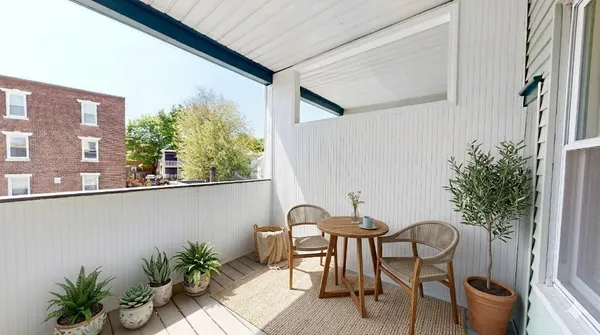 a view of balcony with table and chairs potted plants