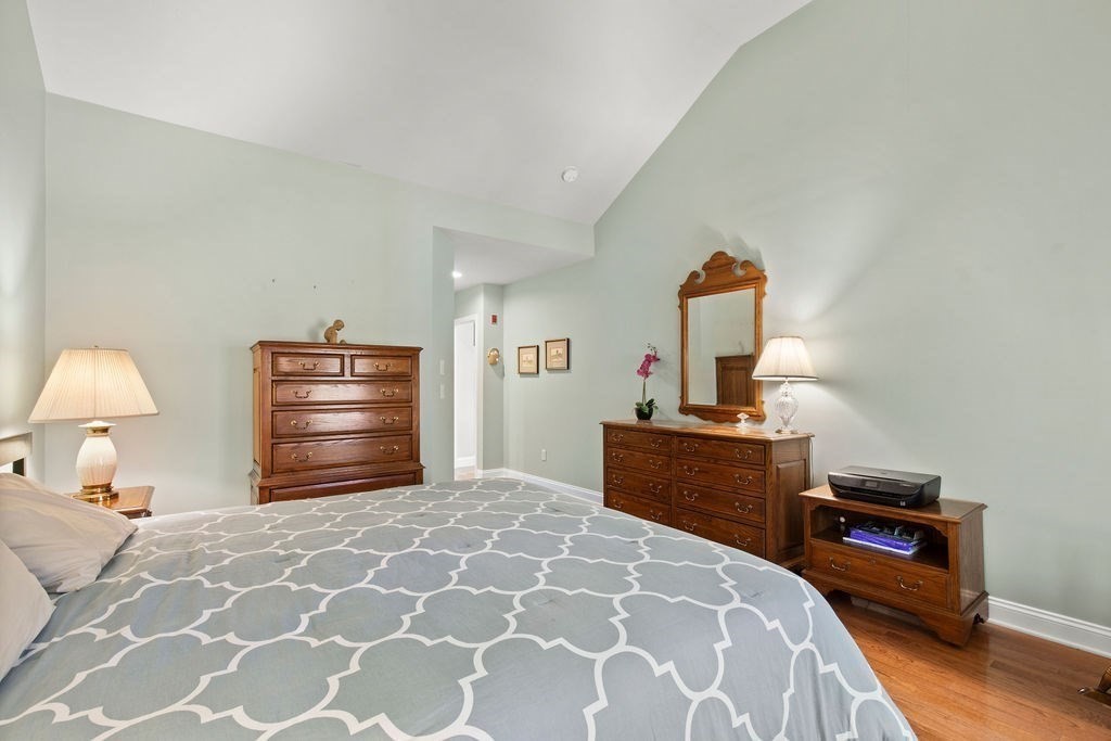 44 Stratford Ridge, Unit 44 Mashpee, MA 02649 - Photo 17 of 40 a bedroom with a bed and a lamp on dresser