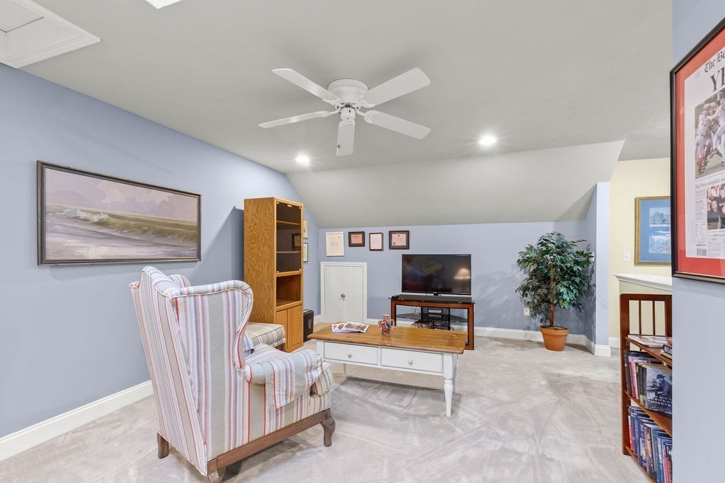 44 Stratford Ridge, Unit 44 Mashpee, MA 02649 - Photo 22 of 40 a living room with furniture a bookshelf and a flat screen tv
