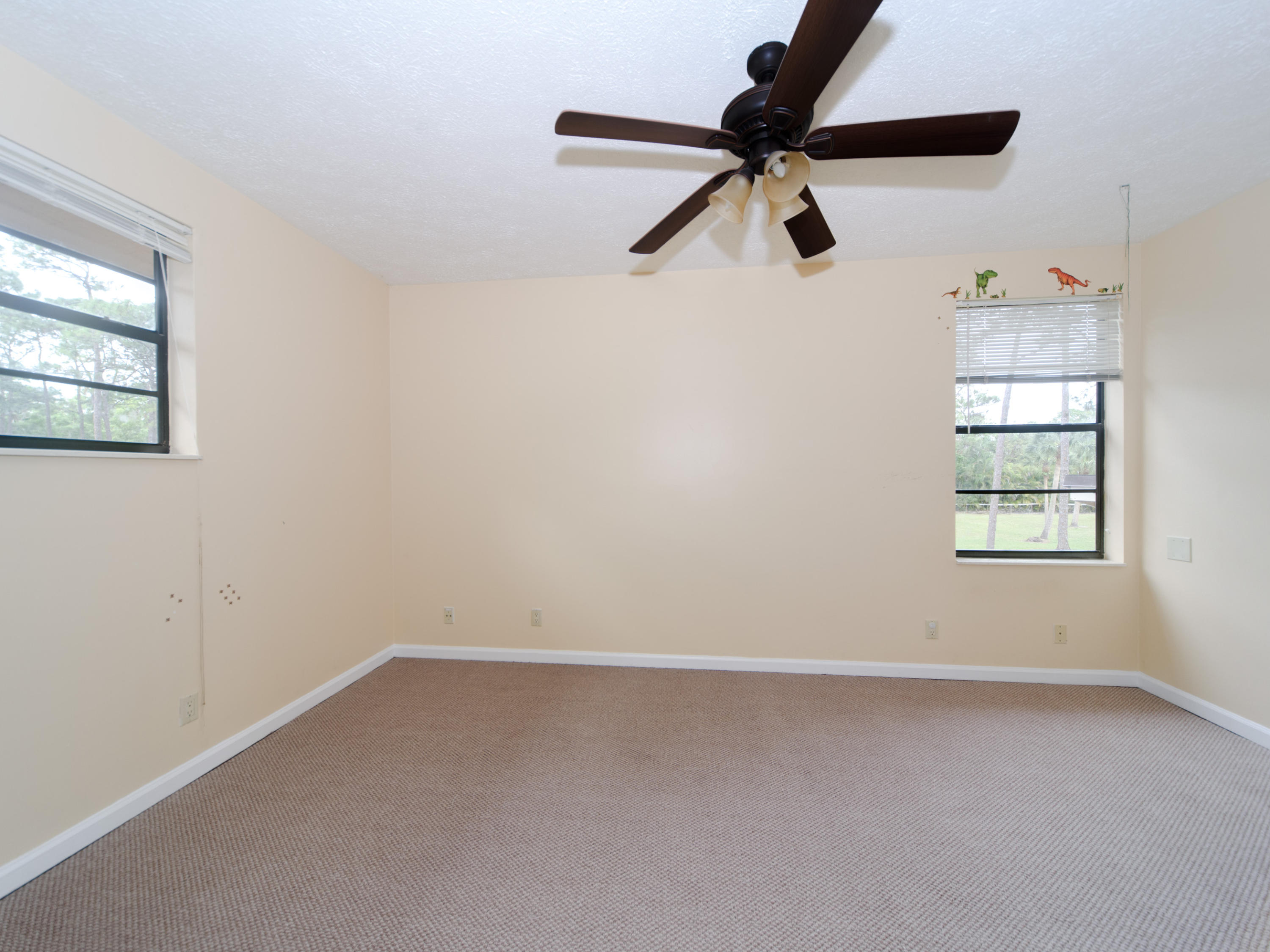 2477 West G Road Loxahatchee, FL 33470 - Photo 59 of 61 an empty room with windows and ceiling fan