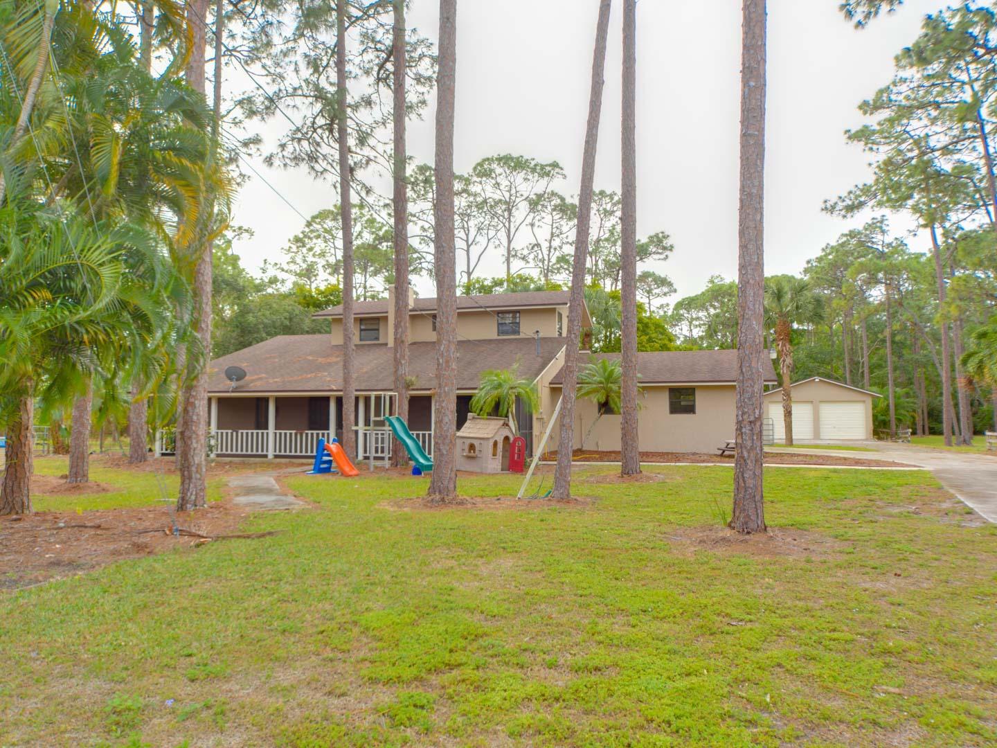 2477 West G Road Loxahatchee, FL 33470 - Photo 6 of 61 a view of a house with a yard patio and fire pit